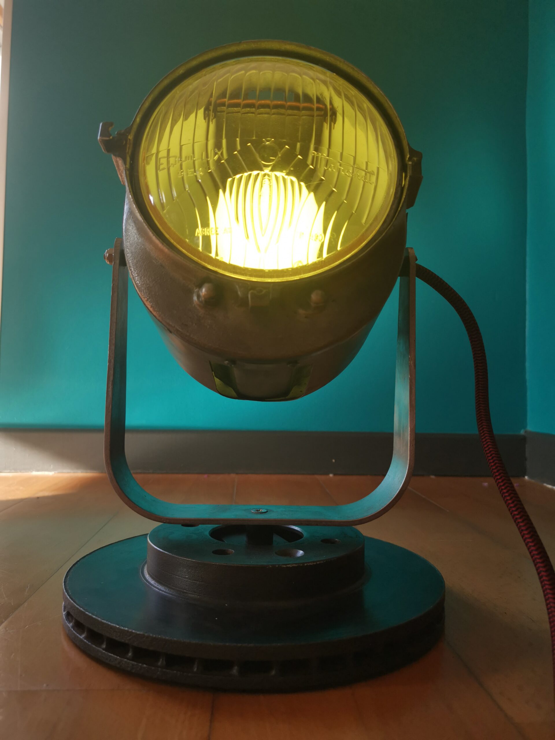 Lampe upcyclée à partir d’un projecteur vintage restauré, verre de phare de voiture ancienne, style industriel brut.