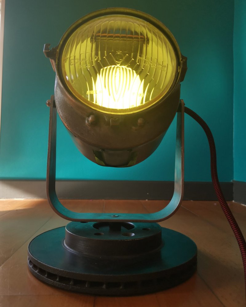 Lampe upcyclée à partir d’un projecteur vintage restauré, verre de phare de voiture ancienne, style industriel brut.